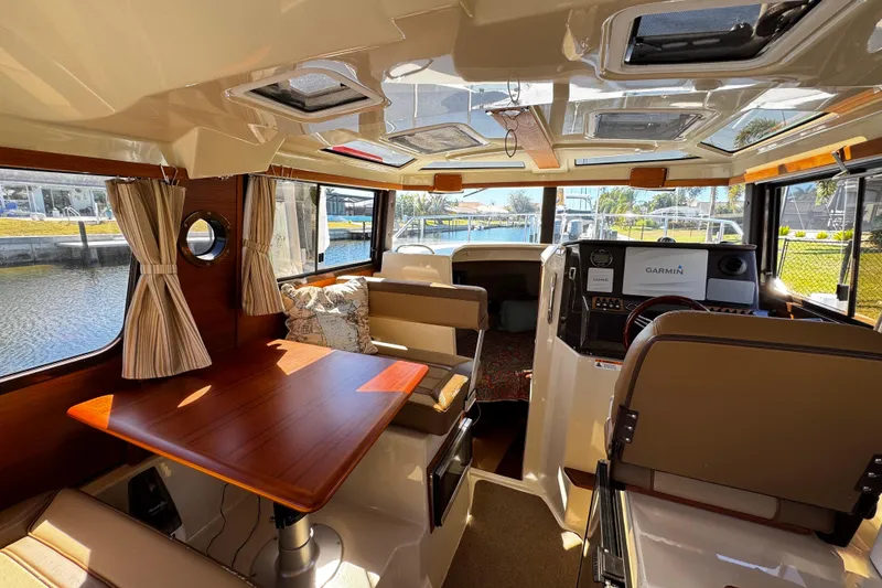Slide: The Image of Interior of 2020 Ranger Tugs R-25 boat with dining area and helm station. - 9