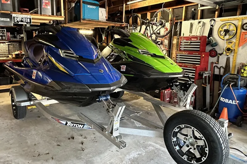 Slide: The Image of Two 2017 Yamaha WaveRunner FX Cruiser SVHO jet skis on a trailer in a garage. - 2