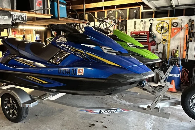 Slide: The Image of 2017 Yamaha WaveRunner FX Cruiser SVHO in a garage, blue and green models on a trailer. - 6