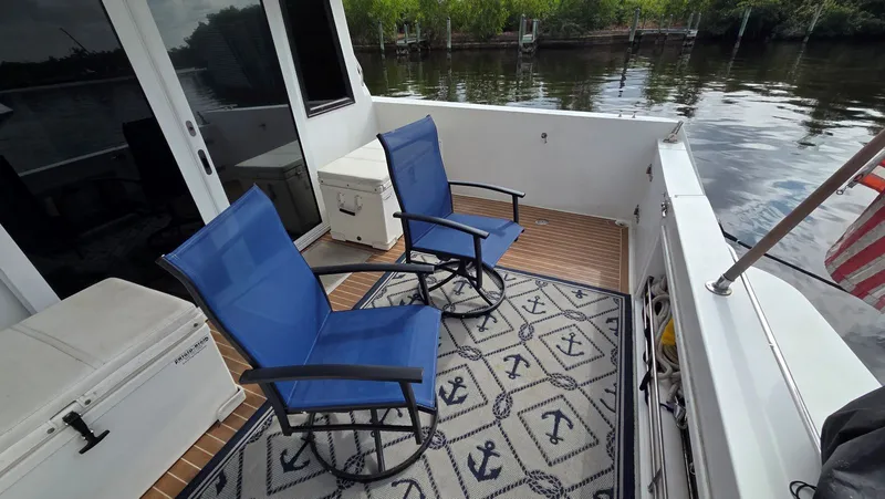 Slide: The Image of Deck of a 1998 Navigator 5300 with blue chairs and anchor-patterned rug. - 17