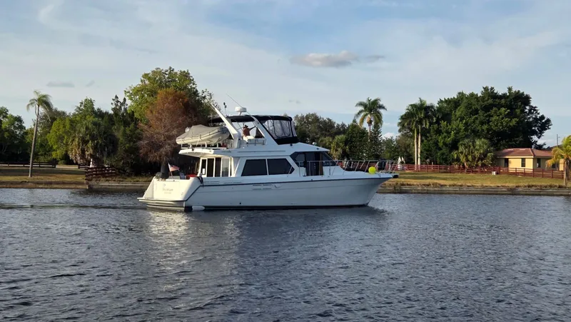 Slide: The Image of 1998 Navigator 5300 yacht on calm water with tropical backdrop. - 3