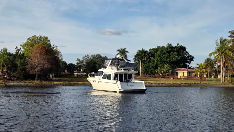 Slide: The Image of 1998 Navigator 5300 yacht on calm water with tropical backdrop. - 4