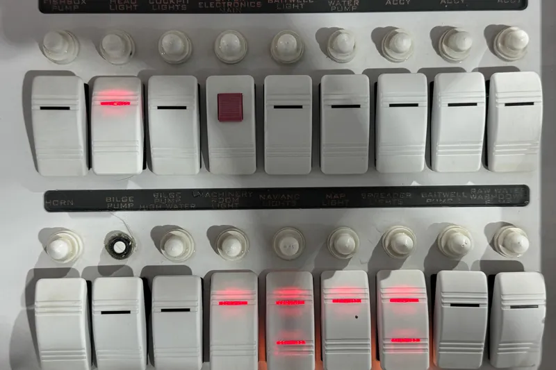 Slide: The Image of Control panel of a 2005 Donzi 32 ZF Open boat with labeled switches and indicators. - 13