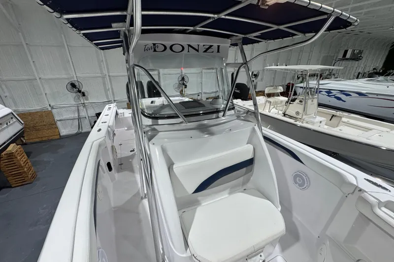 Slide: The Image of 2005 Donzi 32 ZF Open boat with blue canopy in a showroom. - 22