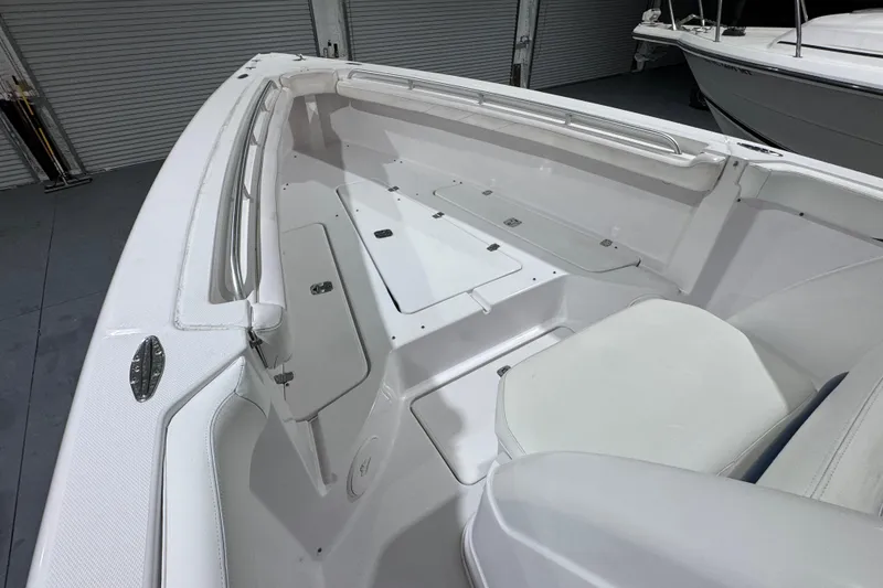 Slide: The Image of 2005 Donzi 32 ZF Open boat interior with white seating and storage compartments. - 24