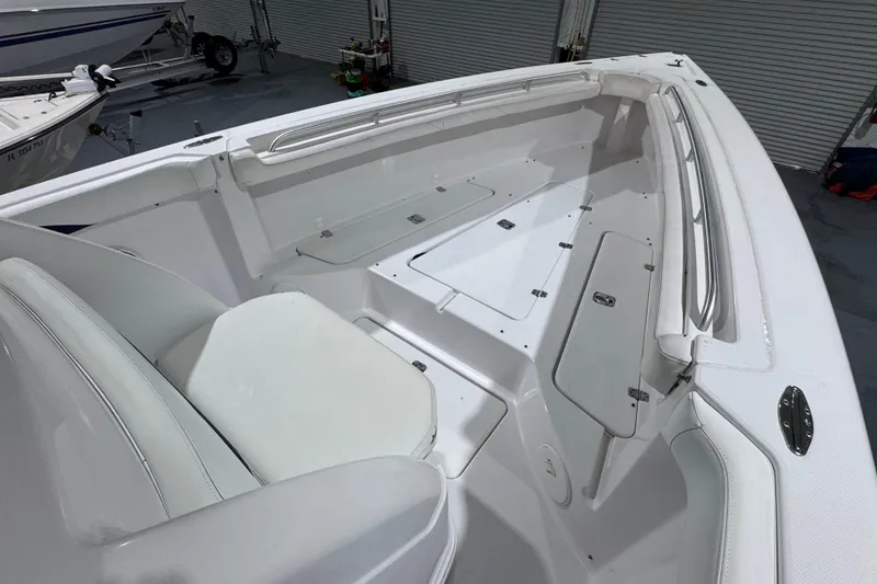 Slide: The Image of 2005 Donzi 32 ZF Open boat interior with white seating and storage compartments. - 25