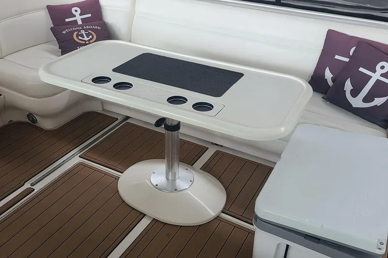 Slide: The Image of Interior of 2001 Sea Ray Sundancer 460 with table and nautical-themed cushions. - 16