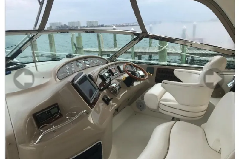 Slide: The Image of 2001 Sea Ray Sundancer 460 helm with luxurious seating and modern controls, dockside view. - 20