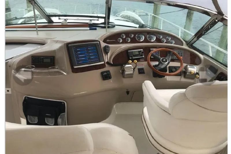 Slide: The Image of Cockpit of 2001 Sea Ray Sundancer 460 yacht with steering wheel and navigation controls. - 30
