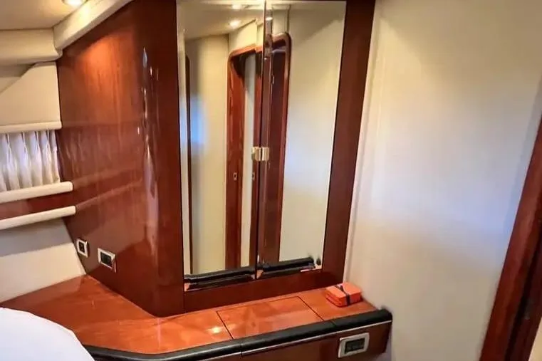 Slide: The Image of Interior of 2001 Sea Ray Sundancer 460 yacht with wood paneling and mirrored cabinet. - 43