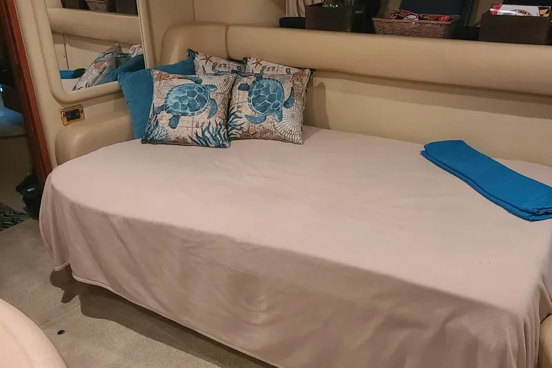 Slide: The Image of Interior of 2001 Sea Ray Sundancer 460 with turtle-themed pillows on a bed. - 46