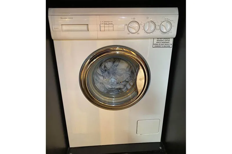 Slide: The Image of Front-loading washing machine with control dials, displaying clothes inside the drum. - 54