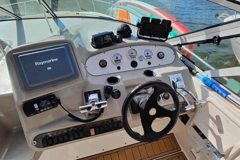 Slide: The Image of 2003 Cruisers Yachts 3470 Express helm with Raymarine electronics and steering wheel. - 13