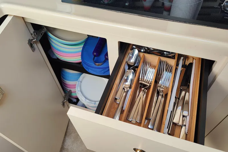 Slide: The Image of Cutlery drawer and colorful plates in 2003 Cruisers Yachts 3470 Express kitchen. - 19