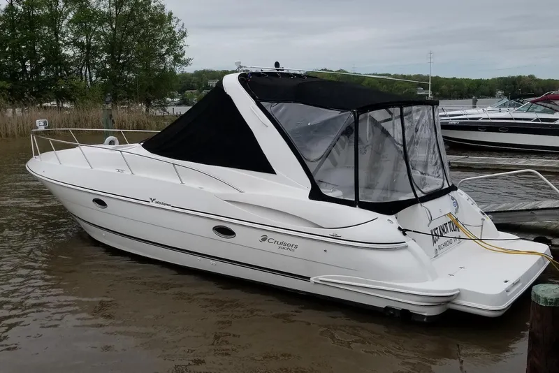 Slide: The Image of 2003 Cruisers Yachts 3470 Express docked, featuring sleek design and black canopy. - 2