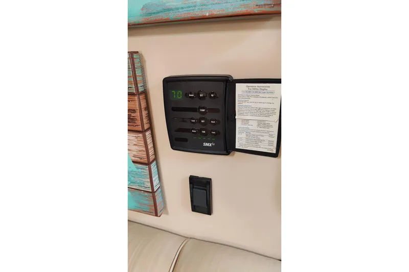 Slide: The Image of Control panel inside 2003 Cruisers Yachts 3470 Express, displaying temperature settings and instructions. - 21