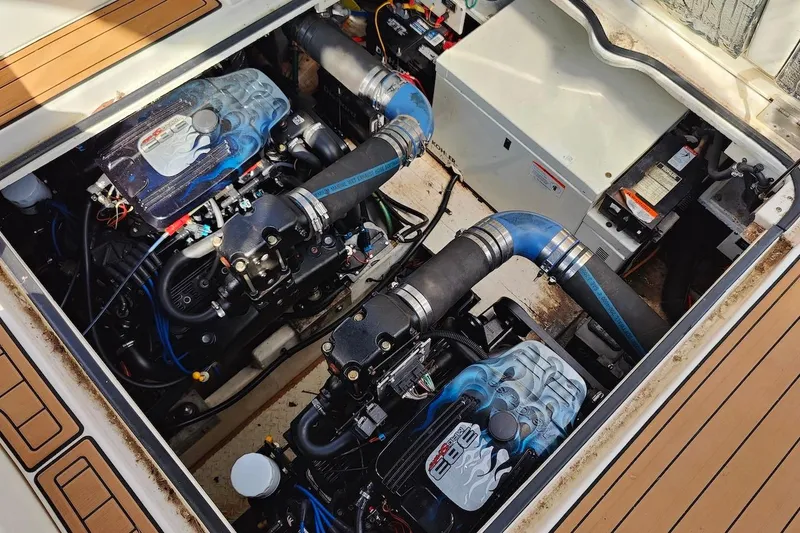Slide: The Image of 2003 Cruisers Yachts 3470 Express engine compartment with dual engines and blue hoses. - 27