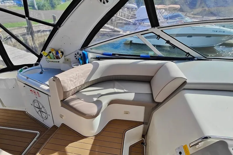 Slide: The Image of 2003 Cruisers Yachts 3470 Express interior with seating and sink, docked at marina. - 5