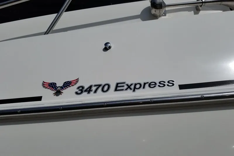 Slide: The Image of 2003 Cruisers Yachts 3470 Express boat with American eagle emblem. - 16