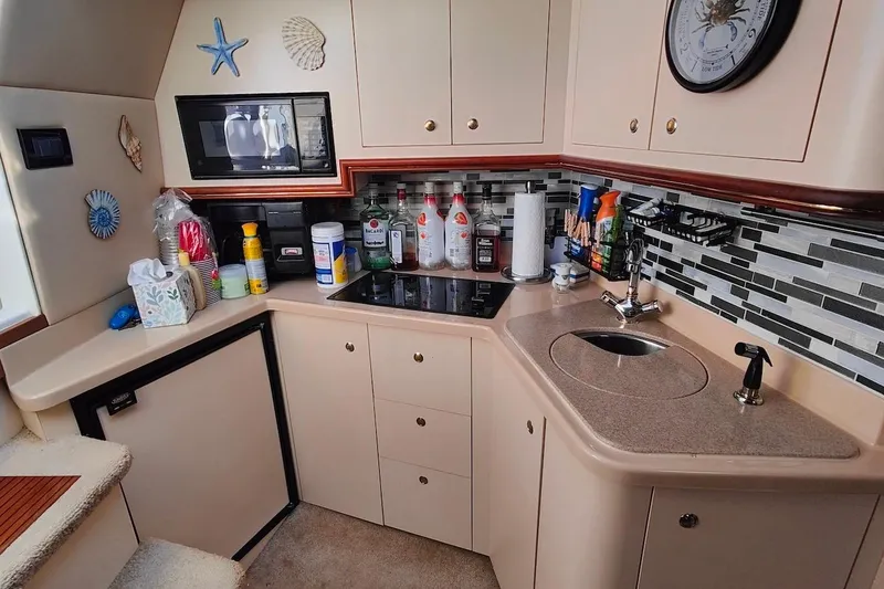 Slide: The Image of 2003 Cruisers Yachts 3470 Express kitchen with modern appliances and nautical decor. - 18