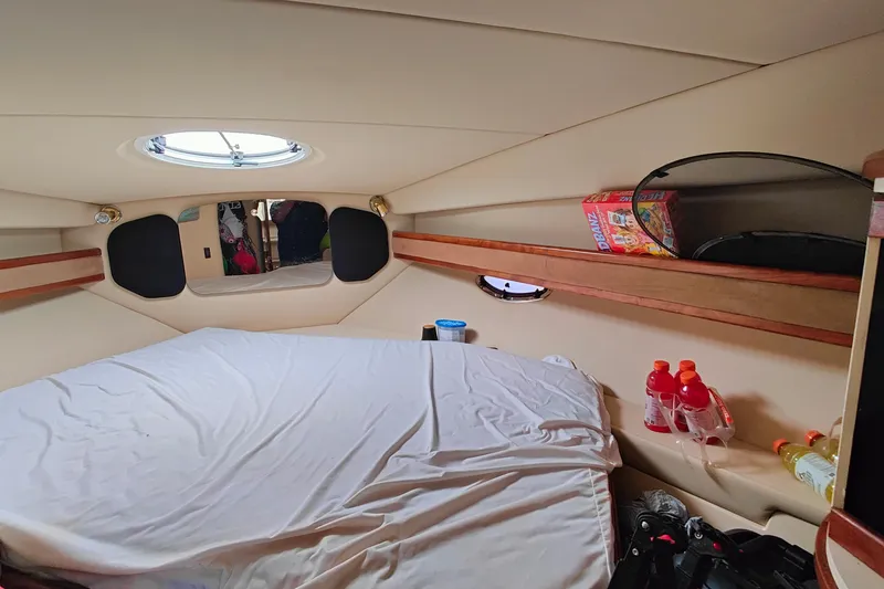 Slide: The Image of 2003 Cruisers Yachts 3470 Express cabin interior with bed and storage shelves. - 22