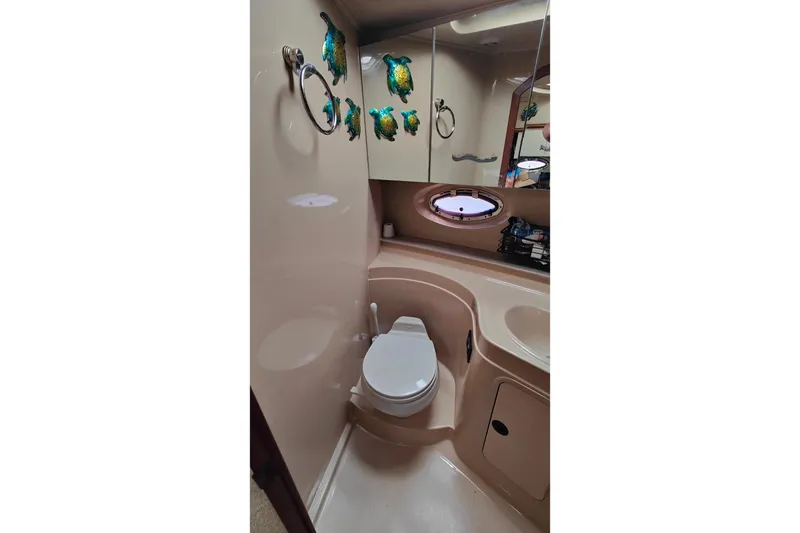Slide: The Image of 2003 Cruisers Yachts 3470 Express bathroom with marine decor and porthole window. - 25