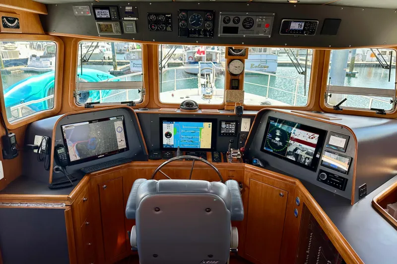 Slide: The Image of Pilothouse of 2003 Nordhavn 47 yacht with advanced navigation equipment and panoramic windows. - 11