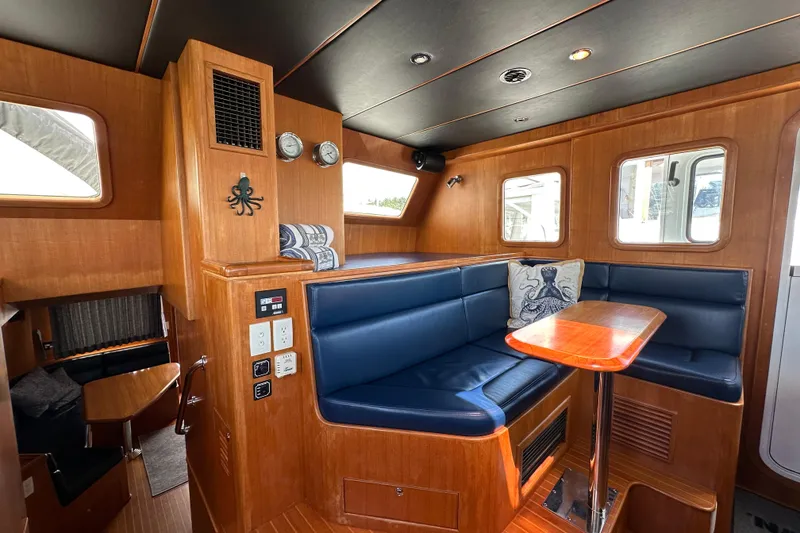 Slide: The Image of Luxurious 2003 Nordhavn 47 yacht interior with blue seating and wooden accents. - 12