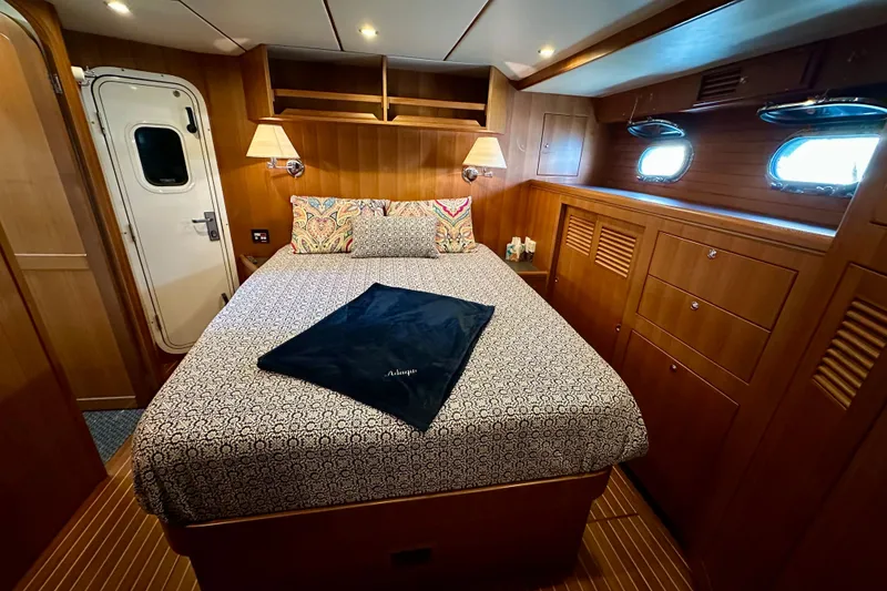 Slide: The Image of Luxurious cabin interior of 2003 Nordhavn 47 yacht with cozy bed and wooden furnishings. - 14