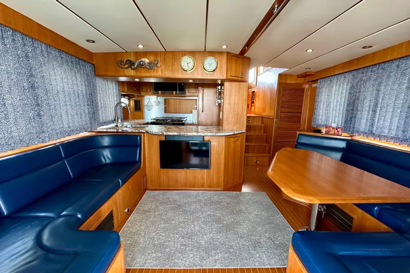Slide: The Image of Luxurious 2003 Nordhavn 47 yacht interior with wood finish and blue seating. - 6