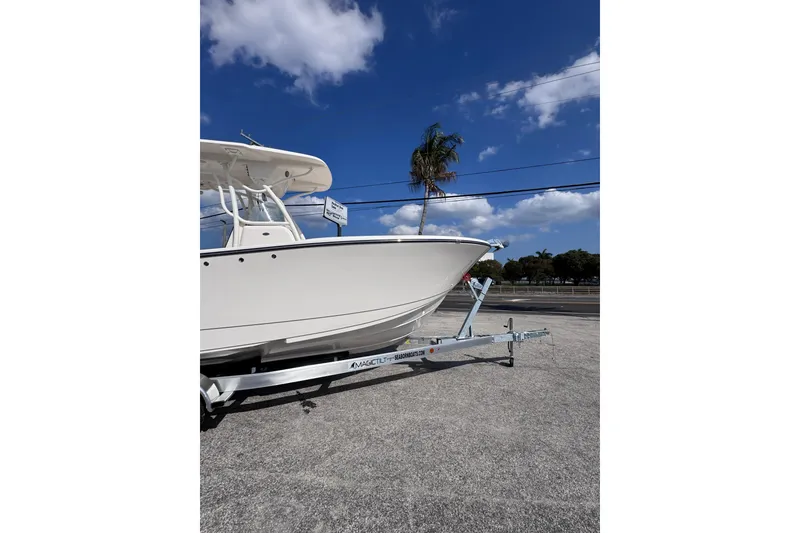 Slide: The Image of 2025 Sea Born SX239 Offshore boat on trailer under clear blue sky. - 2