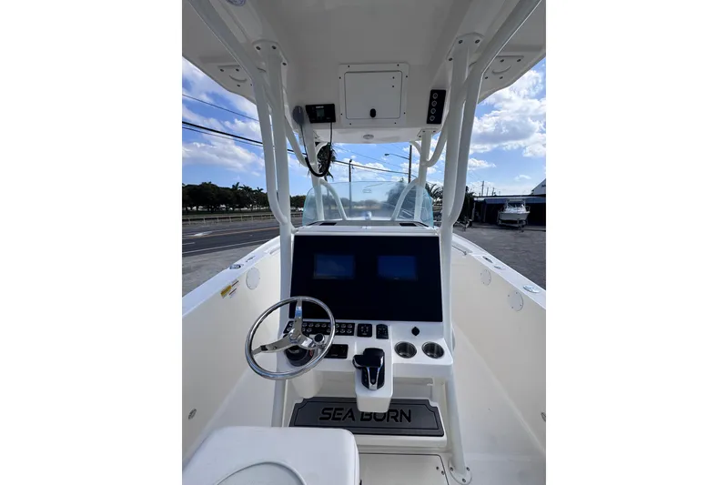 Slide: The Image of 2025 Sea Born SX239 Offshore boat dashboard with steering wheel and navigation screens. - 23