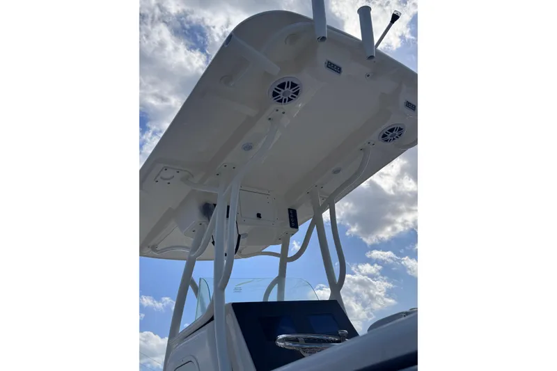 Slide: The Image of 2025 Sea Born SX239 Offshore boat with T-top and speakers against a cloudy sky. - 31