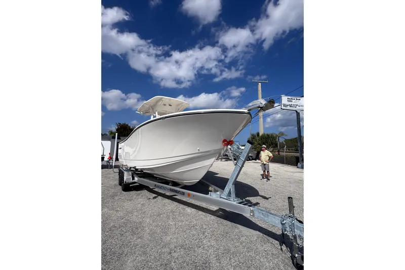 Slide: The Image of 2025 Sea Born SX239 Offshore boat on trailer under blue sky. - 4
