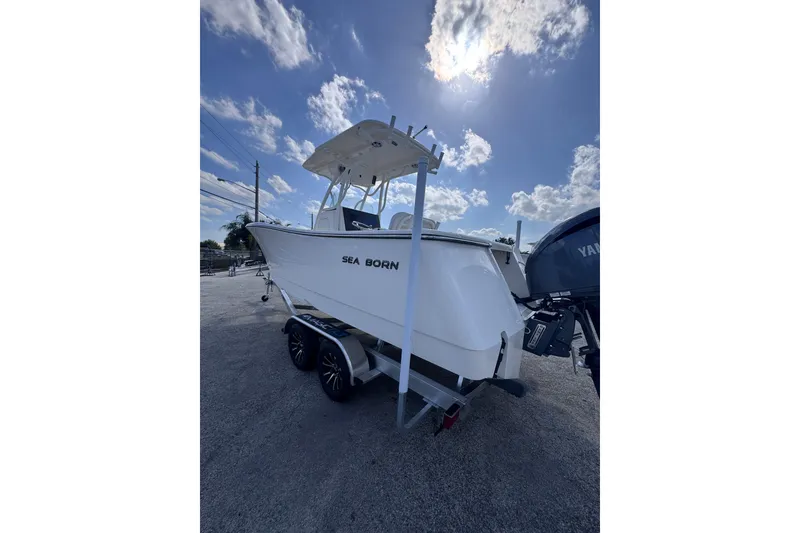 Slide: The Image of 2025 Sea Born SX239 Offshore boat on trailer under a bright sky. - 5