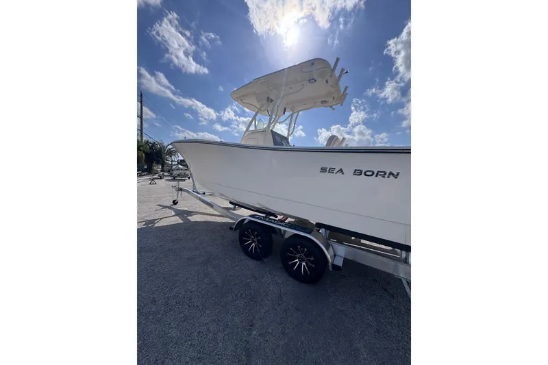 Slide: The Image of 2025 Sea Born SX239 Offshore boat on trailer under sunny sky. - 6