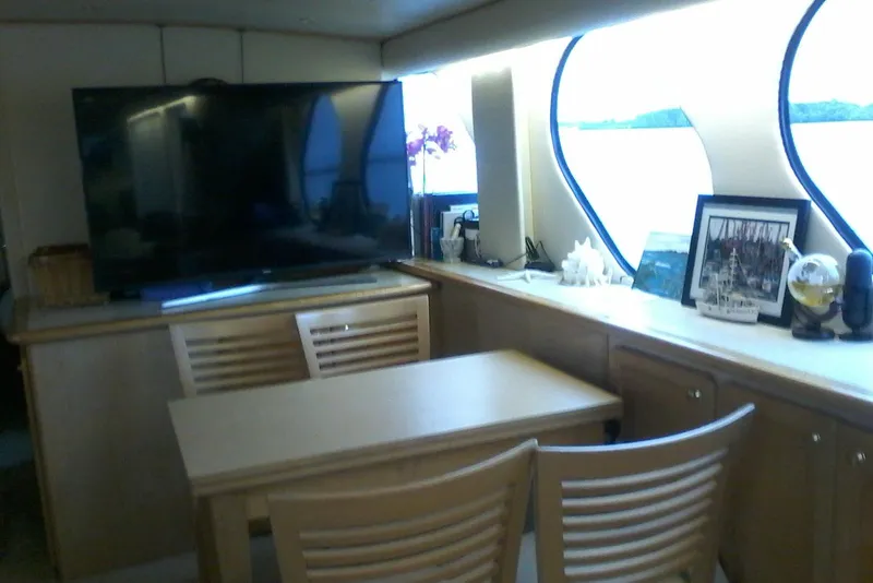 Slide: The Image of Interior of 2000 Bluewater 5800 Millenium yacht with TV, table, and decor. - 11