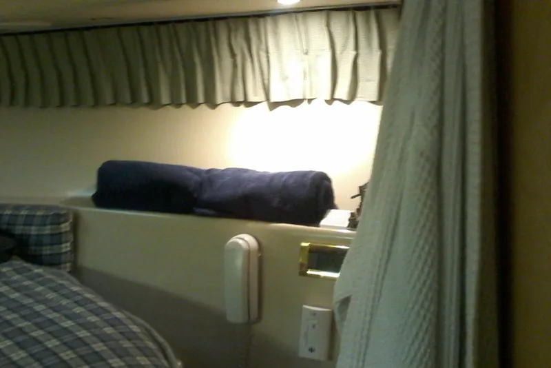 Slide: The Image of Interior of 2000 Bluewater 5800 Millenium yacht with bed, curtain, and wall-mounted phone. - 12