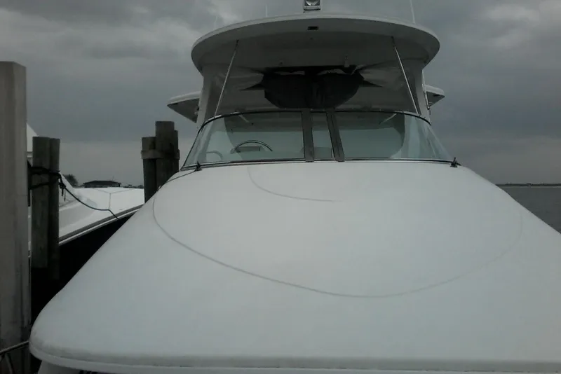 Slide: The Image of Front view of a 2000 Bluewater 5800 Millenium yacht docked under cloudy skies. - 28