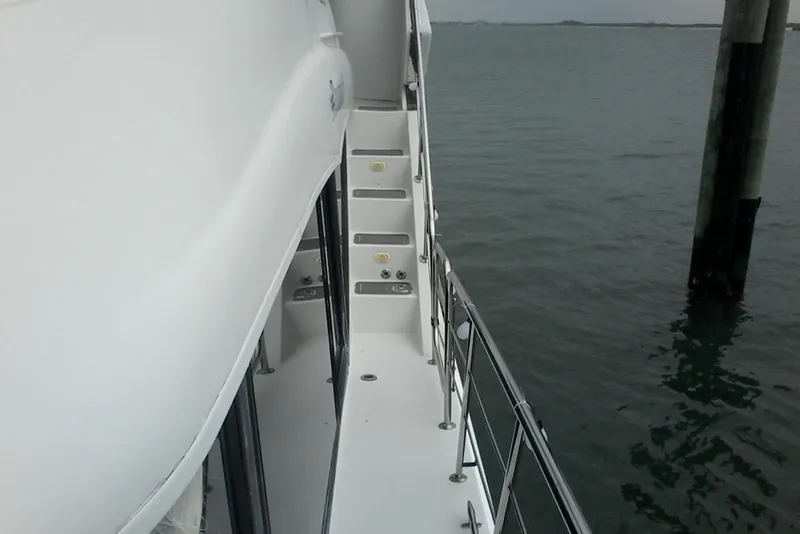 Slide: The Image of Side view of 2000 Bluewater 5800 Millenium yacht with stairs and railing over water. - 29