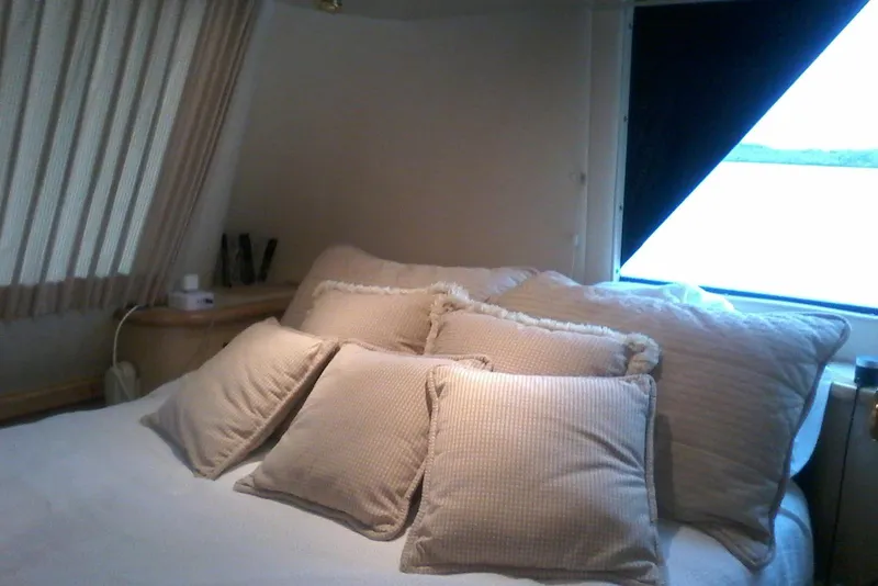 Slide: The Image of Luxurious bedroom interior of 2000 Bluewater 5800 Millenium yacht with plush pillows and window view. - 3