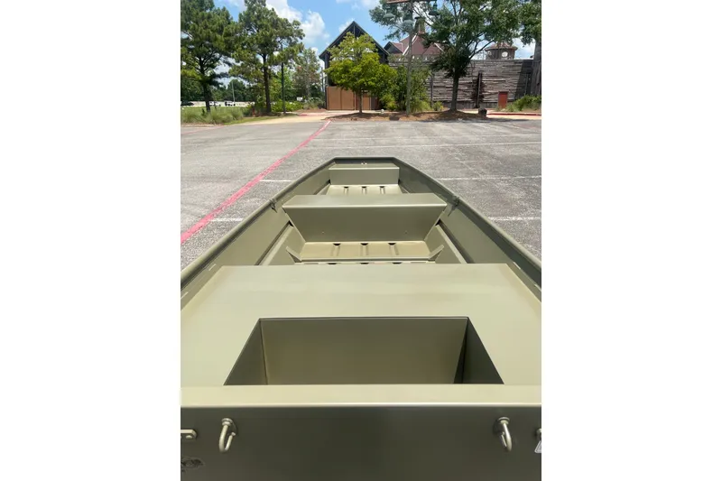 Slide: The Image of 2026 Tracker Grizzly 14 Jon boat in a parking lot, showcasing interior seating and storage. - 10
