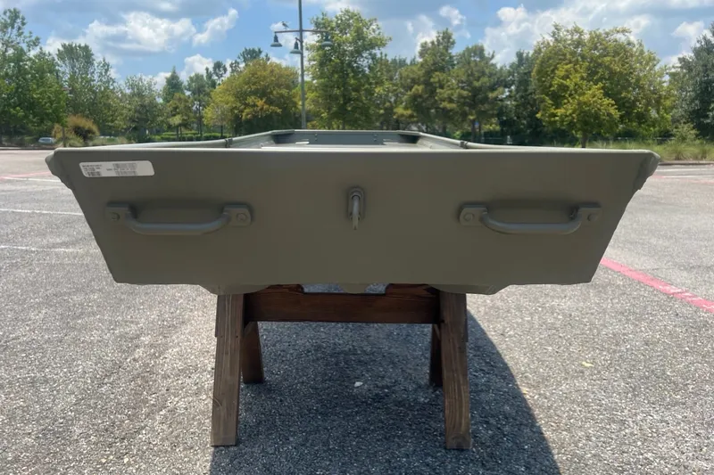 Slide: The Image of 2026 Tracker Grizzly 14 Jon boat displayed outdoors on a wooden stand. - 4