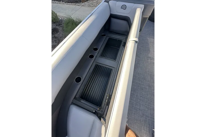 Slide: The Image of 2026 Sun Tracker Party Barge 16 DLX seating area with storage compartments and cup holders. - 38