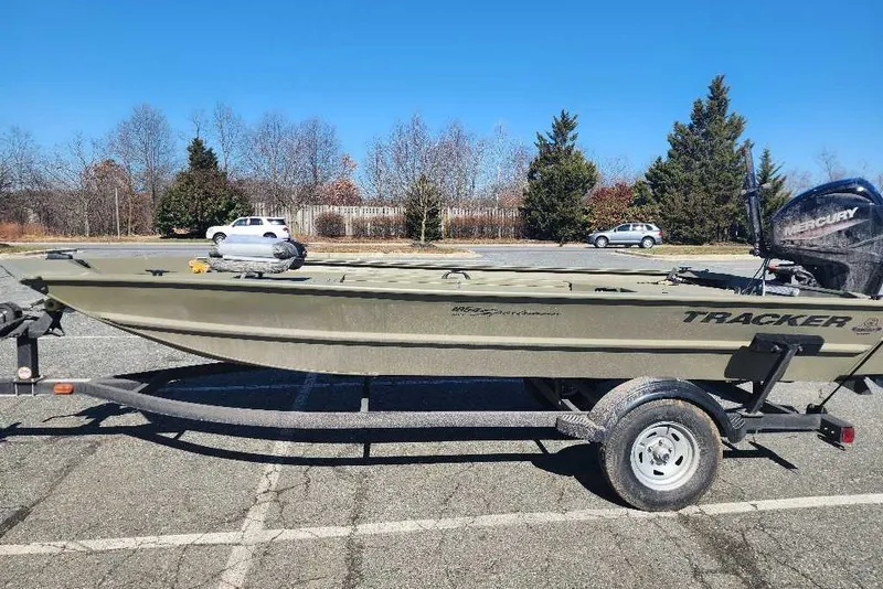 The Image of 2026 Tracker Grizzly 1654 T Sportsman boat on trailer in parking lot. - 0