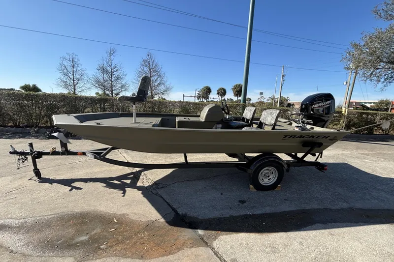 Slide: The Image of 2026 Tracker Grizzly 1754 SC boat on trailer, parked outdoors under clear sky. - 2