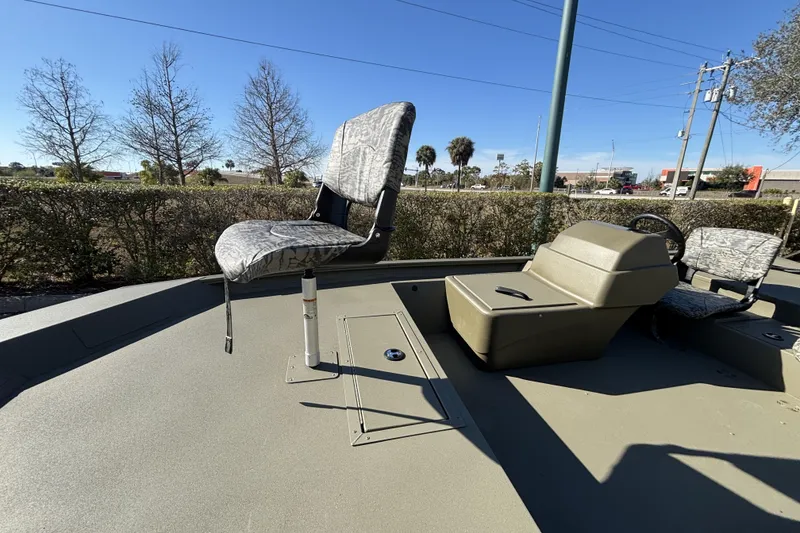Slide: The Image of 2026 Tracker Grizzly 1754 SC boat interior with seating and console, outdoors. - 3