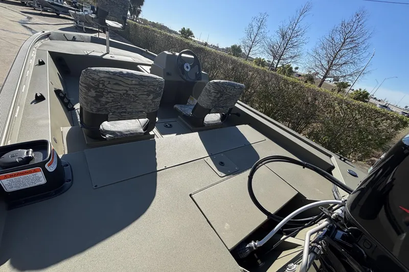 Slide: The Image of 2026 Tracker Grizzly 1754 SC boat interior with camo seats and steering console. - 4