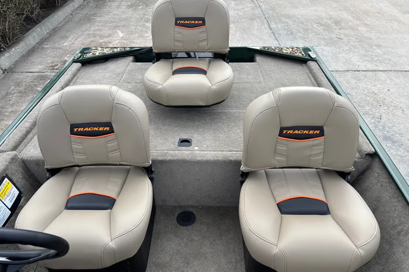 Slide: The Image of 2026 Tracker Bass Tracker Classic Limited boat seats, beige with orange accents, on a concrete surface. - 14