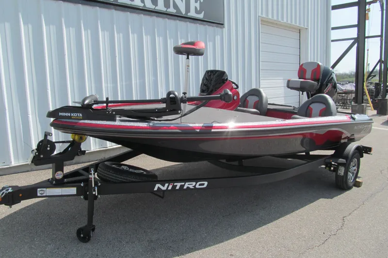 Slide: The Image of 2026 Nitro Z17 fishing boat with Minn Kota trolling motor, parked outside a marine facility. - 91
